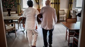Illustration - Une résidente âgée se promène avec une aide-soignante le 5 juillet 2018, dans un établissement d'hébergement pour personnes âgées dépendantes (EHPAD) à Paris.