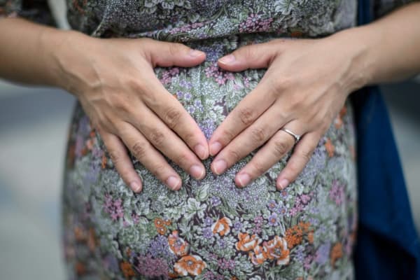 Les mains d'une femme enceinte sur son ventre (photo d'illustration)