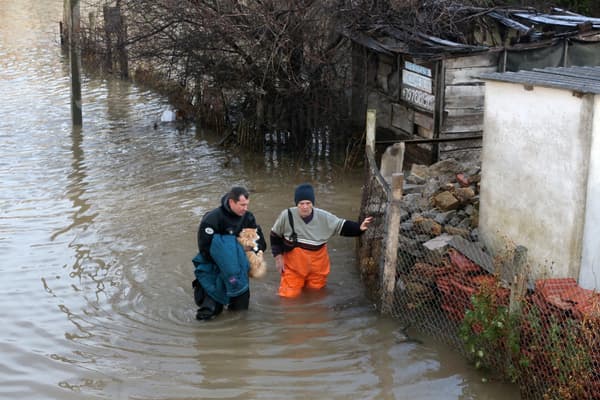 Ratownik trzyma kota i pomaga kobiecie podczas ewakuacji mieszkańców zalanej wioski Pribyzhnye na Krymie, 27 listopada 2023 r.