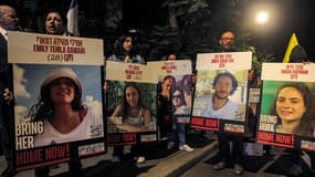 Des manifestants tiennent des portraits d'otages israéliens lors d'une manifestation de familles d'otages retenus dans la bande de Gaza par le Hamas depuis le 7 octobre 2023, devant la résidence du Premier ministre israélien à Jérusalem, le 24 octobre 2024.

