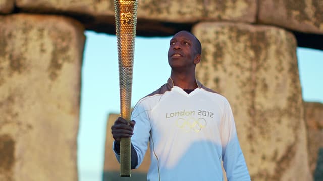 Michael Johnson avec la torche olympique en 2012