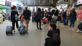 Des voyageurs attendent leur train le 30 juillet 2017 à la gare Montparnasse, à Paris, après une panne