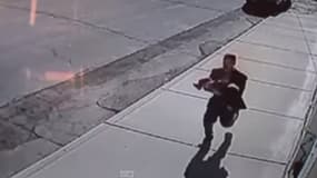 Une caméra de vidéosurveillance a capté la fuite de l'homme, avec un enfant dans les bras.