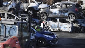 AFP via Google Trad: "Une photo prise le 1er janvier 2022 dans une cour de démolition de voitures à Strasbourg montre des voitures incendiées récupérées par des employés de la ville après le réveillon du Nouvel An dans la ville de Strasbourg, dans l'est de la France."