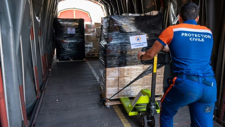 Un membre de la Protection civile française charge un wagon de fret avec des palettes d'aide humanitaire à destination des Ukrainiens réfugiés en Roumanie, à Strasbourg le 23 mars 2022