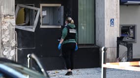 Une membre de la police scientifique inspecte la façade d'un bureau de poste à Roubaix après un braquage à l'explosif, le 12 novembre 2025.