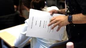 Un professeur tient en mains les sujets de l'épreuve de philosophie du bac, le 15 juin 2022 au lycée Arago à Paris (photo d'illustration). 