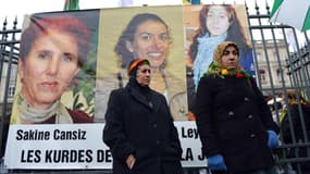 Des femmes se rassemblent devant un portrait des trois militantes assassinées à Paris en 2013