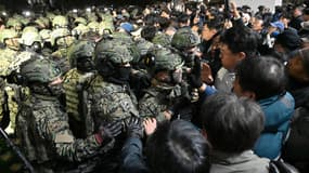 Des soldats tentent de pénétrer dans le bâtiment de l'Assemblée nationale à Séoul, le 4 décembre 2024, après que le président sud-coréen Yoon Suk Yeol a déclaré la loi martiale.