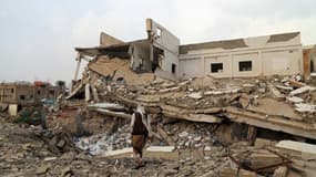 Un yéménite passe devant une école détruite par des bombardements à Taez, le 16 mars 2017