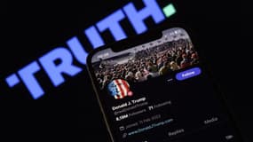 L'image montre un iPhone au premier plan, affichant le compte personnel de Donald Trump sur la plateforme Truth Social. Le logo Truth Social est subtilement visible en arrière-plan, mettant en valeur l'image de marque et l'interface utilisateur du réseau social.