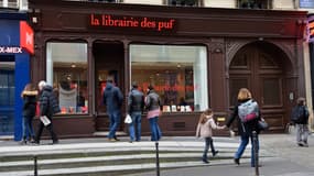 Des personnes passent devant la nouvelle librairie des Presses Universitaires de France (PUF) à Paris le 16 mars 2016. 