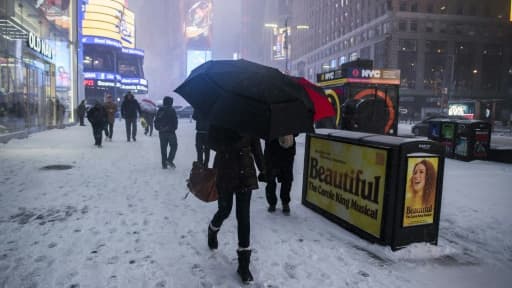 Des passants sur Times Square enneigé à Manhattan le 4 janvier 2018