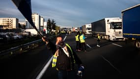 Image d'illustration d'un gilet jaune portant un drapeau français le 24 novembre 2018 sur l'A6 au niveau de Villefranche-sur-Saône (Rhône)