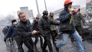 Des opposants évacuent un blessé de la place Maïdan, jeudi 20 février, à Kiev.