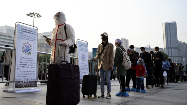 A Wuhan, des personnes font la queue à la gare pour quitter la ville, le 8 avril 2020. 