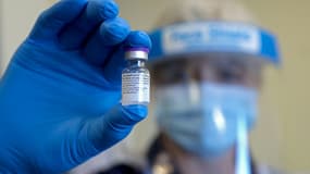 Un employé du service de santé britannique présente une dose du vaccin contre le Covid-19 des laboratoires Pfizer-Biontech, le 17 décembre à Gloucester