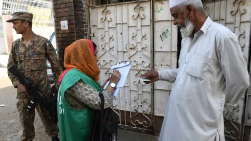 Une employée du bureau de recensement, accompagnée par un soldat, recueille des informations auprès d'un habitant, le 15 mars 2017 à Karachi, au Pakistan Une employée du bureau de recensement, accompagnée par un soldat, recueille des informations auprès d'un habitant, le 15 mars 2017 à Karachi, au Pakistan
