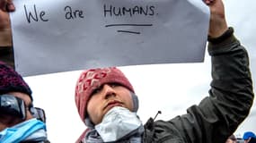 Un migrant iranien, bouche cousue, proteste mercredi contre le démantèlement du camp où il "survit", à Calais. 