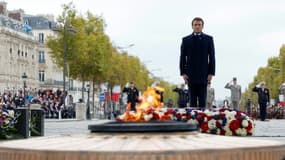 Le président Emmanuel Macron (c) devant la tombe du Soldat inconnu à l'Arc de Triomphe, lors des commémorations du 104e anniversaire de l'Armistice de 1918, le 11 novembre 2022 à Paris