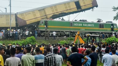 Des personnes se rassemblent près du site d'une collision entre un train de passagers et un train de marchandises à Nirmaljote, près de la gare de Rangapani, dans l'État indien du Bengale occidental, le 17 juin 2024.