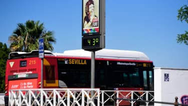 Un bus passe devant un thermomètre affichant 43°C à Séville, le 26 avril 2023. 
