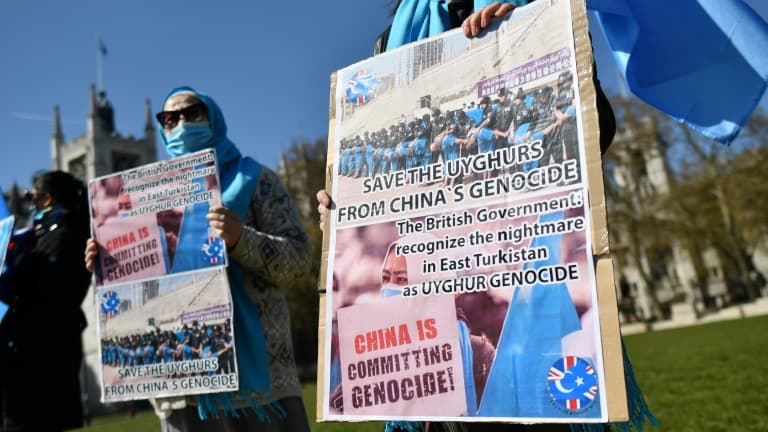 Des membres de la communauté ouïghoure tiennent des pancartes demandant au parlement britannique la reconnaissance d'un génocide sur les Ouïghours par la Chine, à Londres (Royaume-Uni), le 22 avril 2021