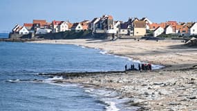 Des gendarmes français utilisent un tracteur pour tirer un bateau de migrants endommagé après une tentative ratée de traverser la Manche qui a conduit à la mort de 8 personnes près de la plage d'Ambleteuse, le 15 septembre 2024. 