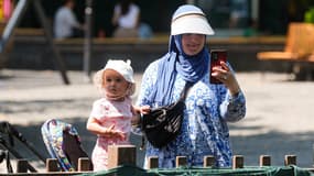 Une mère et son enfant portent des chapeaux pour se protéger du soleil, à Ankara, en Turquie, le 24 juillet 2025.