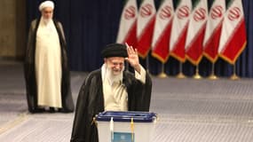 Le guide suprême iranien, l'ayatollah Ali Khamenei, fait un signe de la main lors du dépôt de son bulletin de vote au second tour des élections législatives à Téhéran, le 28 juin 2024.