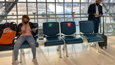 Des sièges marqués d'une croix rouge pour respecter la distanciation physique entre les passagers dans une salle d'embarquement à l'aéroport de Bangkok, le 31 mars 2021 en Thailande