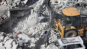 Des équipes travaillent à déblayer les débris après l'explosion d'un dépôt d'armes dans le nord de la Syrie