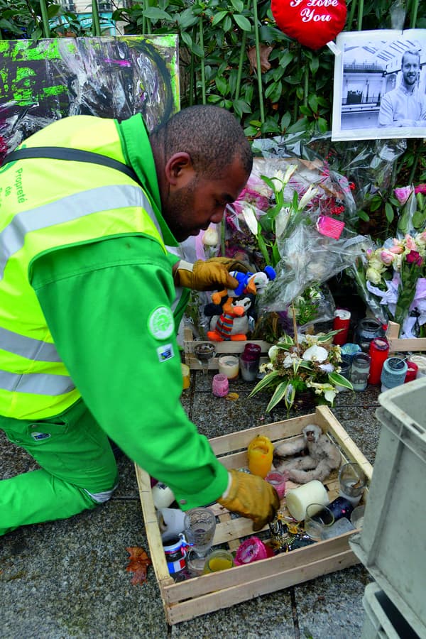 Un employé de la mairie collectant des objets d'un mémorial en face du Bataclan, le 10 décembre 2015 Un employé de la mairie collectant des objets d'un mémorial en face du Bataclan, le 10 décembre 2015