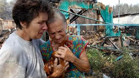 Habitantes au milieu de maisons calcinées en périphérie de la ville de Voronej, dans le centre de la Russie. Selon les autorités, les feux de forêt qui font rage dans cette partie du pays, touchée par la sécheresse et une canicule sans précédent, ont fait