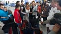 A l'aéroport de Roissy-Charles de Gaulle, une employée de l'Office français de l'Immigration et de l'Intégration (au centre) donne des explications à une famille de Roms dont certains membres s'apprêtent à embarquer pour un retour volontaire en Roumanie.