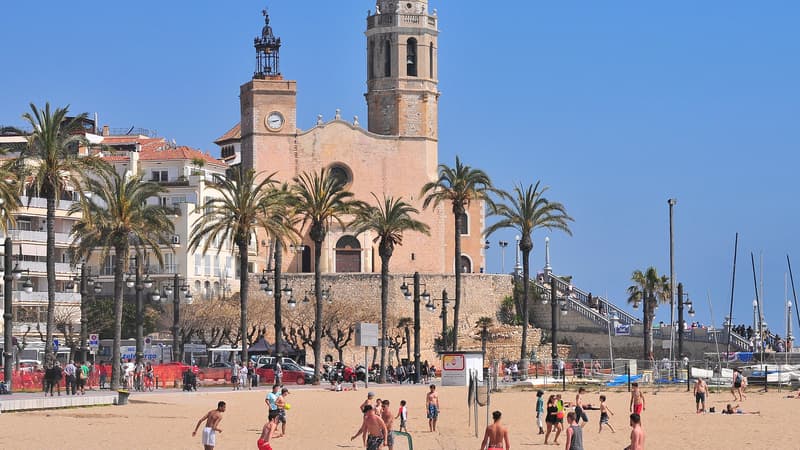 Des jeunes gens en train de jouer au beach volley sur une plage de Sitges, près de Barcelone.
