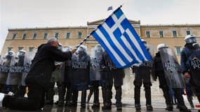 Manifestation contre l'austérité devant le parlement grec à Athènes. La réunion des dirigeants politiques grecs prévue ce mardi pour valider les réformes exigées par les bailleurs de fonds d'Athènes en échange d'un deuxième plan d'aide a été repoussée à m