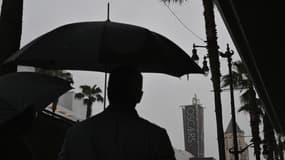 Un passant avec un parapluie sur Hollywood Boulevard, avant les Oscars, aux États-Unis, le 10 mars 2023