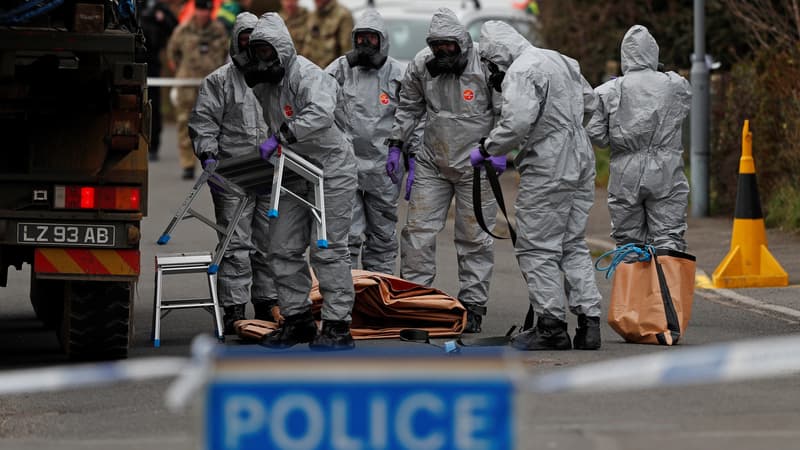 Des militaires britanniques en tenue protectrice déplacent un véhicule lié à l'empoisonnement d'un ex-espion russe, le 14 mars 2018 à Salisbury en Grande-Bretagne.