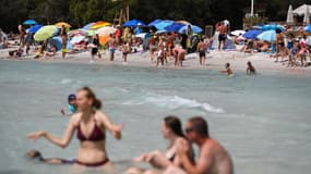 Des touristes profitent du soleil sur la plage de Santa Giulia, près de Porto Vecchio, sur l'île méditerranéenne française de Corse, le 9 juillet 2023.