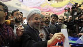 Vote de Hassan Rohani à Téhéran. Le plus modéré des candidats à l'élection présidentielle iranienne, est en position de l'emporter dès le premier tour, selon des résultats préliminaires diffusés samedi par les autorités iraniennes. /Photo prise le 14 juin