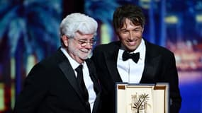 Le réalisateur Sean Baker recevant la Palme d'or pour "Anora" de la part de George Lucas le 25 mai 2024 au Festival de Cannes