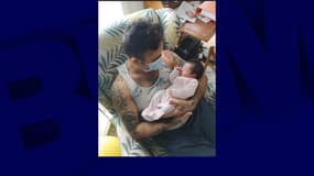 John tenant dans ses bras sa fille pour la première fois