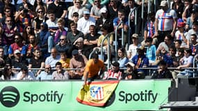 Un supporter du Barça retire un drapeau espagnol des tribunes du Camp Nou lors du match contre l'Atlético de Madrid, le 23 avril 2023.