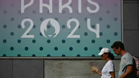 Une femme s'évente sous la chaleur pendant les JO-2024 devant l'Arena Paris Sud à Paris, le 29 juillet 2024