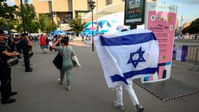 Un supporter brandit un drapeau israélien avant la rencontre Israël-Mali au Parc des princes, le 24 juillet 2024 à Paris