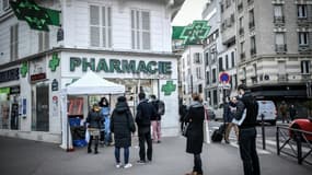 Des personnes attendent de se faire tester au Covid-19 dans une pharmacie, le 23 décembre 2021  à Paris
