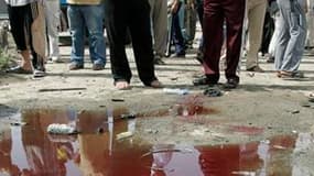 Mare de sang dans le quartier chiite de Sadr City après une attaque à la bombe à Bagdad. Plusieurs attentats dirigés contre des quartiers et des lieux de culte chiites en Irak ont fait au moins 56 morts et plus de cent blessés vendredi. /Photo prise le 23