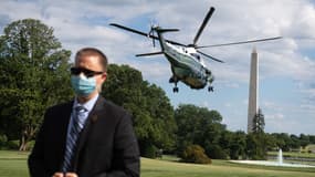 Un agent des services secrets debout devant l'hélicoptère du président Donald Trump