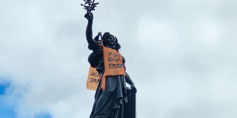 Des militants accrochent un chasuble marqué des mots "Agent orange écocide" sur la statue de la République, à Paris, le 4 mai 2024.
